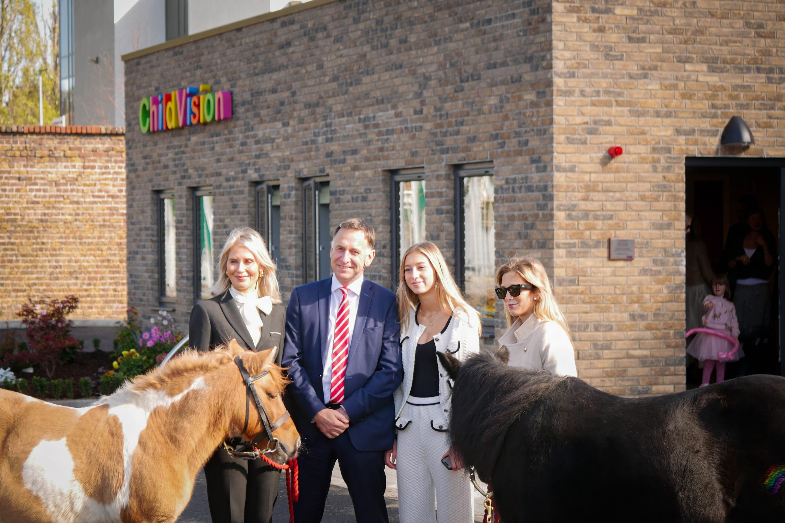 de Bromhead family standing with two horses in front of the new centre